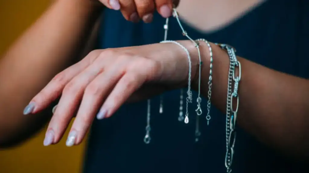 Close up shot of women's choose silver bracelets on her hands