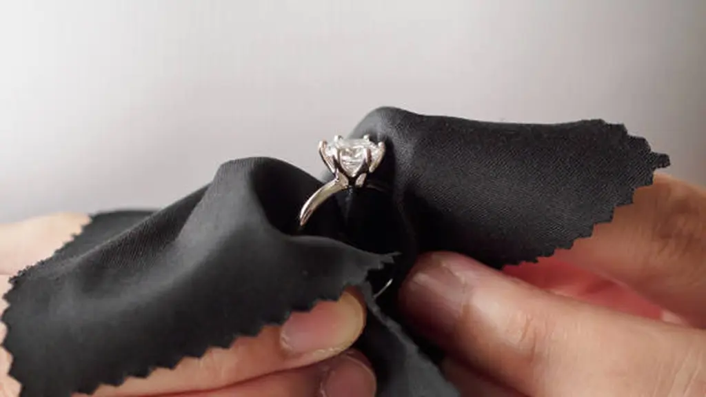 Jeweller cleaning jewelry diamond ring with fabric cloth
