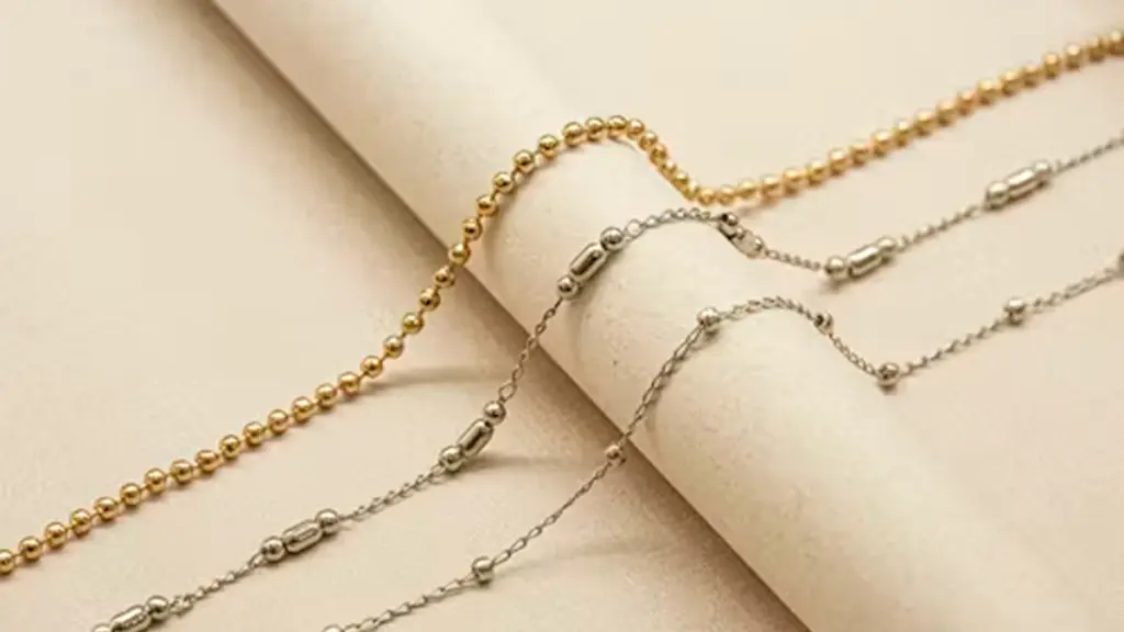 a roll of paper with a gold plated and silver chain on top of it